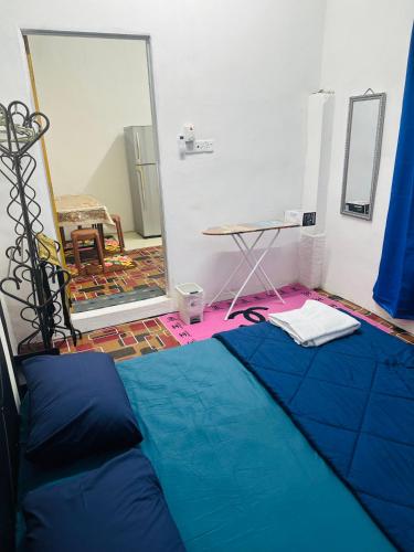 a bedroom with a blue bed and a mirror at WANN HOMESTAY 80c in Kaki Bukit