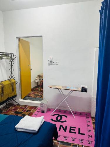 a room with a table and a sign on the floor at WANN HOMESTAY 80c in Kaki Bukit