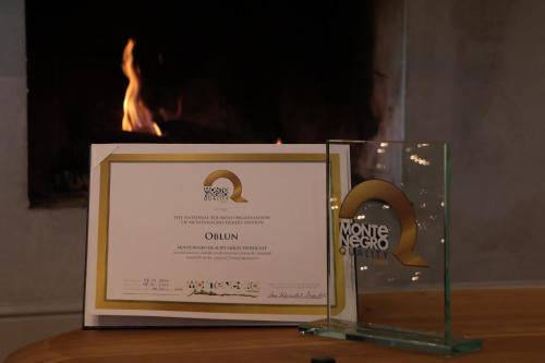 a frame with a sign in front of a fire at Oblun Eco Resort - Mirror Cabin in Podgorica