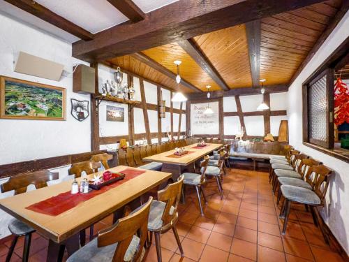 a restaurant with wooden ceilings and tables and chairs at Gasthof Adler in Ebenweiler