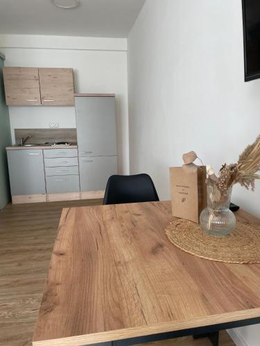 a room with a wooden table with a vase on it at Gästezimmer im Weingut Kissel in Gundheim