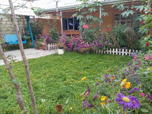 a garden in front of a house with flowers at Chilegir Host in Çilǝgir