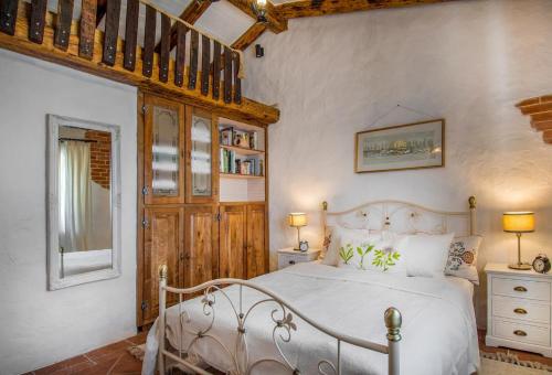 una camera da letto con un letto bianco e un soffitto in legno di Countryside Retreat Villa with Pool,Jaccuzi a Klis