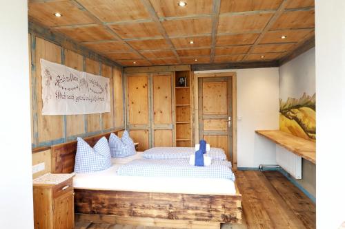 a bed in a room with a wooden ceiling at Familienwanderhof Eggeler in Liesing