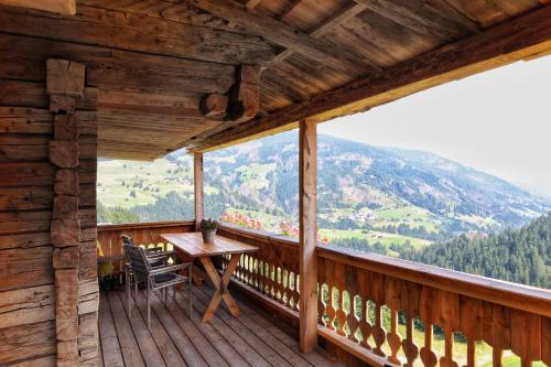 a wooden balcony with a table and chairs on it at Familienwanderhof Eggeler in Liesing