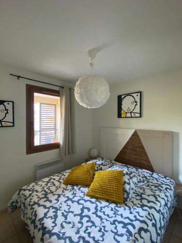 ein Schlafzimmer mit einem Bett mit gelben Kissen in der Unterkunft Escapade Uzétienne Cœur de ville et Parking in Uzès