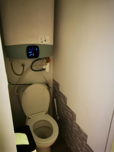 Elle comprend une petite salle de bains pourvue de toilettes et d'une horloge murale. dans l'établissement Studio cabine Cosy bord de mer, à La Grande Motte