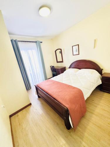 a bedroom with a large bed and a window at Residencial Santo António in Santa Cruz
