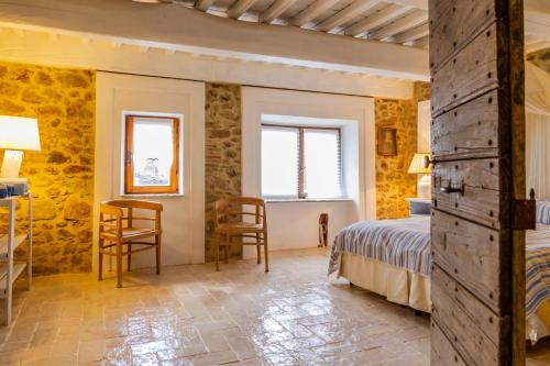 a bedroom with a bed and a table and chairs at Casa Pereta in Magliano in Toscana