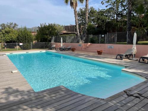 - une piscine dans une cour avec une terrasse en bois dans l'établissement Villa La Rotondo dans la résidence ALTA STRADA piscine partagée chauffée, à Sainte-Lucie de Porto-Vecchio