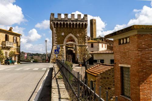 a brick building with a gate on the side of a street at Casa Pereta in Magliano in Toscana