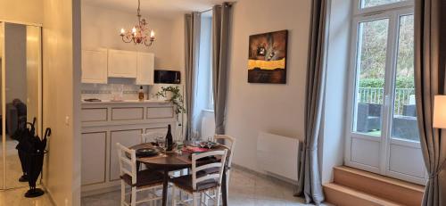 une cuisine et une salle à manger avec une table et une fenêtre dans l'établissement St Nectaire- Appartement Terrasse Privée- 4 personnes, à Saint-Nectaire