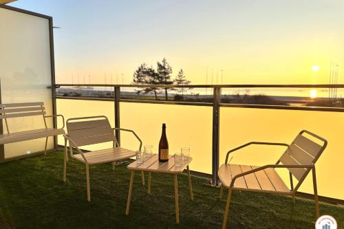 d'une table, de deux chaises et d'une bouteille de vin sur le balcon. dans l'établissement Le Pop Art' - Terrasse Great Sea View and Parking, au Havre