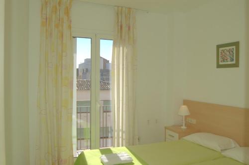 une chambre avec un lit et une fenêtre avec vue dans l'établissement Apto Liss 50 metros de la playa, à Lloret de Mar