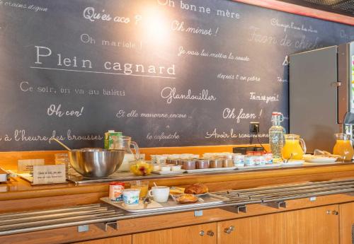 a chalkboard with a menu on the wall in a restaurant at B&B HOTEL Marseille Bonneveine in Marseille