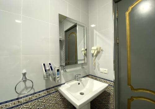 a bathroom with a sink and a mirror at Diyor Hotel in Margilan