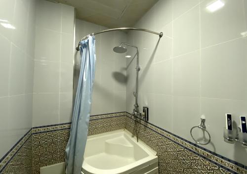 a bathroom with a shower with a toilet and a sink at Diyor Hotel in Margilan