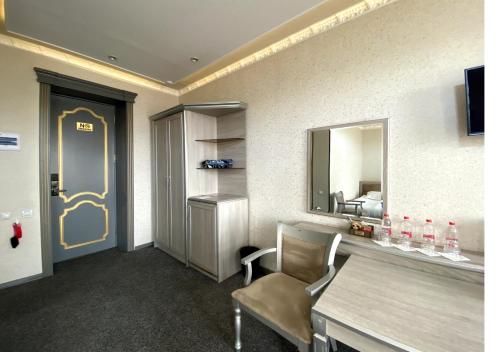 a room with a table and a mirror and a chair at Diyor Hotel in Margilan