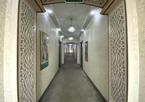 a corridor in a building with paintings on the walls at Diyor Hotel in Margilan