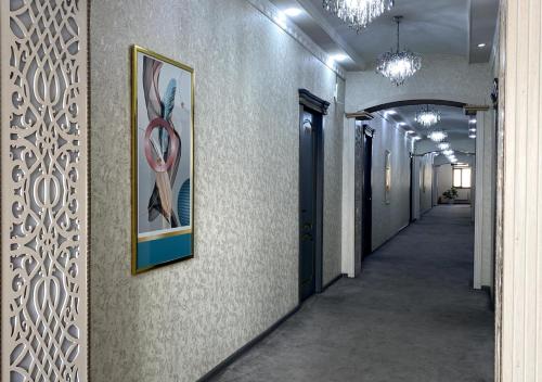 a hallway of an office with a painting on the wall at Diyor Hotel in Margilan