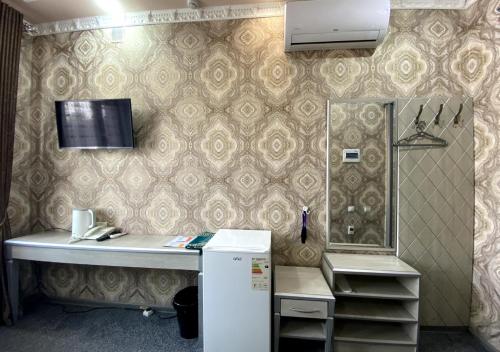 a kitchen with a white counter and a refrigerator at Diyor Hotel in Margilan