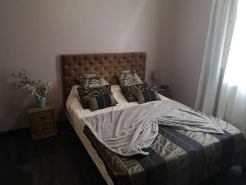 - un lit avec une couverture et des oreillers dans l'établissement Villa provençale, à LʼArbresle