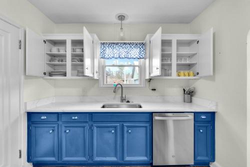 a blue and white kitchen with a sink and a window at Spacious Omaha Retreat in Omaha