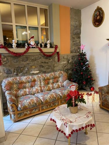 a living room with a couch and a christmas tree at Hôtel les Berges in Chippis