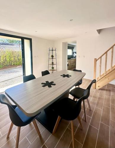 - une table en bois dans une chambre entourée de chaises dans l'établissement L acheneau, à Cheix-en-Retz