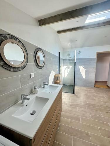 une salle de bain avec un lavabo et un miroir dans l'établissement L acheneau, à Cheix-en-Retz