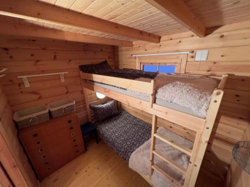 a bedroom in a log cabin with two bunk beds at Nordlands hytta in Meby