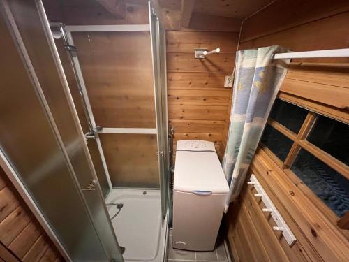 a small bathroom with a toilet and a shower at Nordlands hytta in Meby