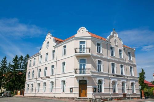 a large white building sitting on the side of a street at Marysienka in Bisztynek