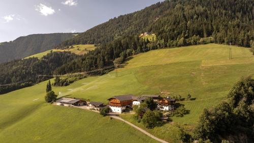 a house on a hill in a green field at Großplonerhof in Luson