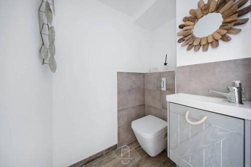 une salle de bain avec toilettes, lavabo et miroir dans l'établissement Hyères Centre-Les Floralies T3/Clim/Garage/balcon by HC, à Hyères