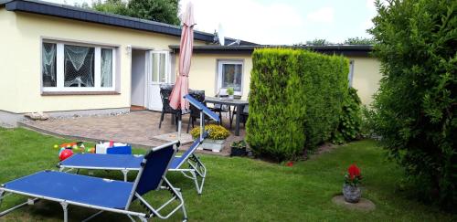 Haus-J-Bull-das-Sonneneck-Ferienwohnung-an-der-schoenen-Ostsee-in-Boergerende-Rethwisch في بورغيريندي-ريثفيش: ساحة بها كراسي ومظلة وطاولة