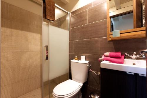 a bathroom with a toilet and a sink at La Maison Bleue in Linxe