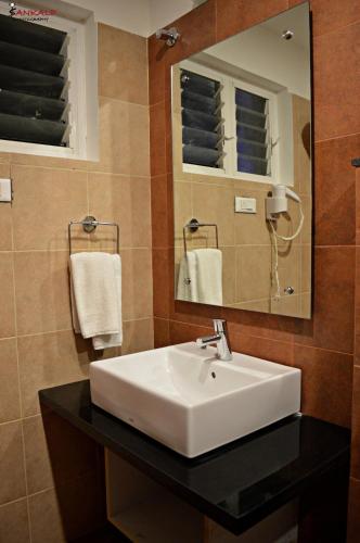 a bathroom with a sink and a mirror and towels at Sepoy Grande Mysore in Mysore