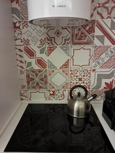 a tea kettle on a table with a tile wall at La dimora dalle Mura in Savona