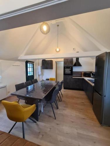 une cuisine et une salle à manger avec une table et des chaises dans l'établissement cottages de la Maye, à Rue