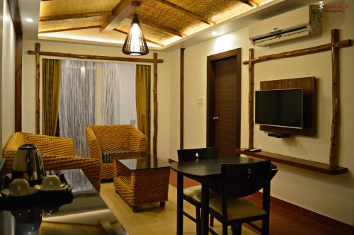 a living room with a table and a tv at Sepoy Grande Mysore in Mysore