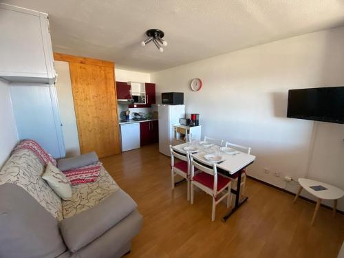 un salon avec un canapé et une table et une cuisine dans l'établissement Appartement face aux montagnes - Belle étoile, à Eyne