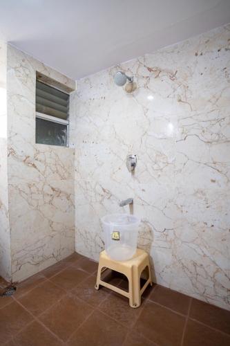 a bathroom with a toilet in a room with marble walls at Hotel Vyshak residency in Mysore