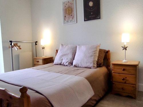 une chambre avec un lit avec deux tables de nuit et deux lampes dans l'établissement Appartement confort 2P/4C, Centre Cauterets, près télécabine, parking à proximité - FR-1-234-333, à Cauterets