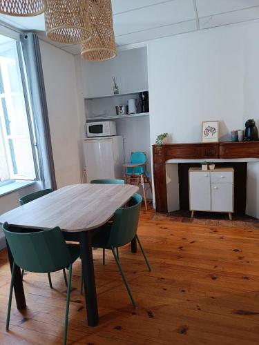 une salle à manger avec une table et des chaises en bois dans l'établissement Appartement chez la fleuriste, à Chaudes-Aigues