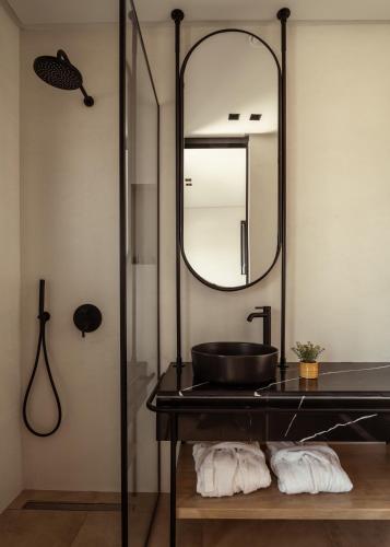 a bathroom with a black sink and a mirror at Vorto Luxury Villas, a Signature Island Retreat, By ThinkVilla in Zakynthos