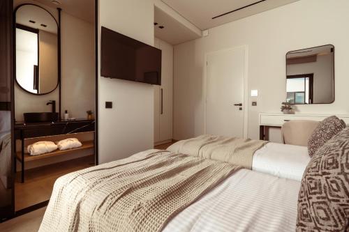 a bedroom with two beds and a mirror at Vorto Luxury Villas, a Signature Island Retreat, By ThinkVilla in Zakynthos