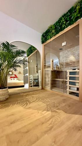 une chambre avec deux grandes fenêtres et une chambre avec une plante dans l'établissement L Anaya Nantes Spa et Sauna, à Rezé