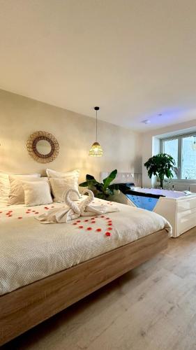 une chambre avec un grand lit et une salle de bain dans l'établissement L Anaya Nantes Spa et Sauna, à Rezé