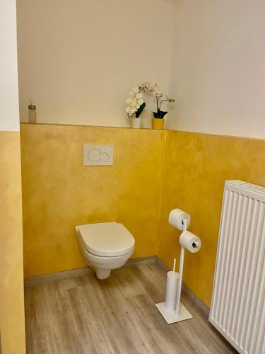 a bathroom with a toilet and a yellow wall at Appartement Ambiente in Waidhofen an der Ybbs